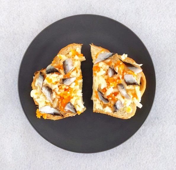 Egg sandwich on white bread on grey plate on white background